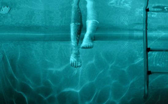 uno de los personajes mojando los pies en la piscina embrujada